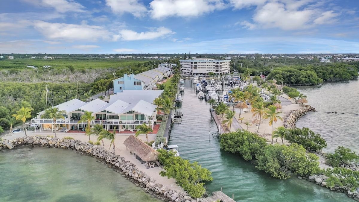 Aerial view of the Kawama Yacht Club peninsula, marina and private beach in Key Largo, Florida