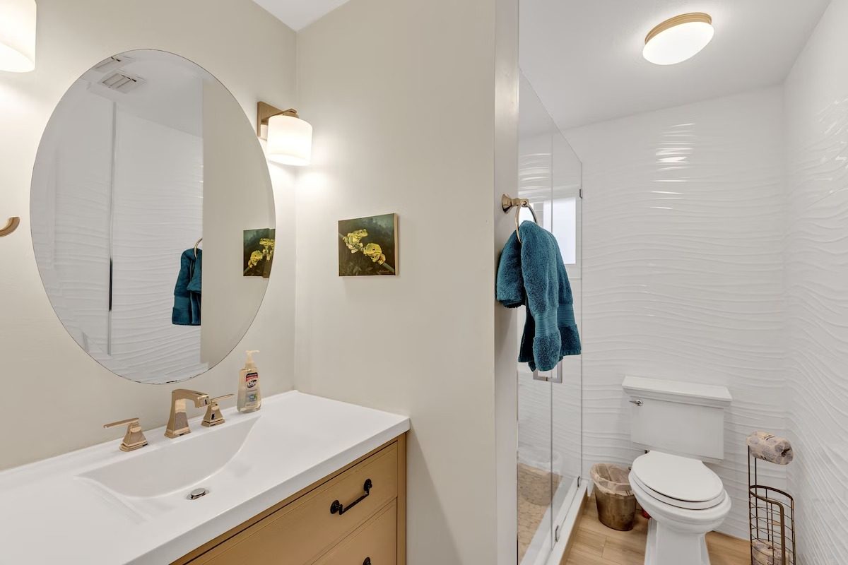 Bathroom with oval mirror and walk-in shower in the renovated Key Largo rental